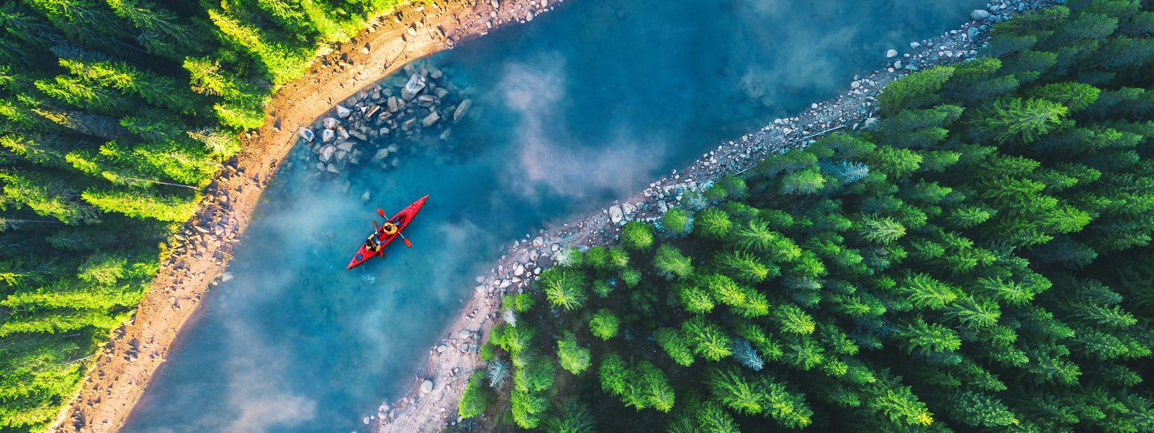 due persone in canoa su un fiume circondato da allberi