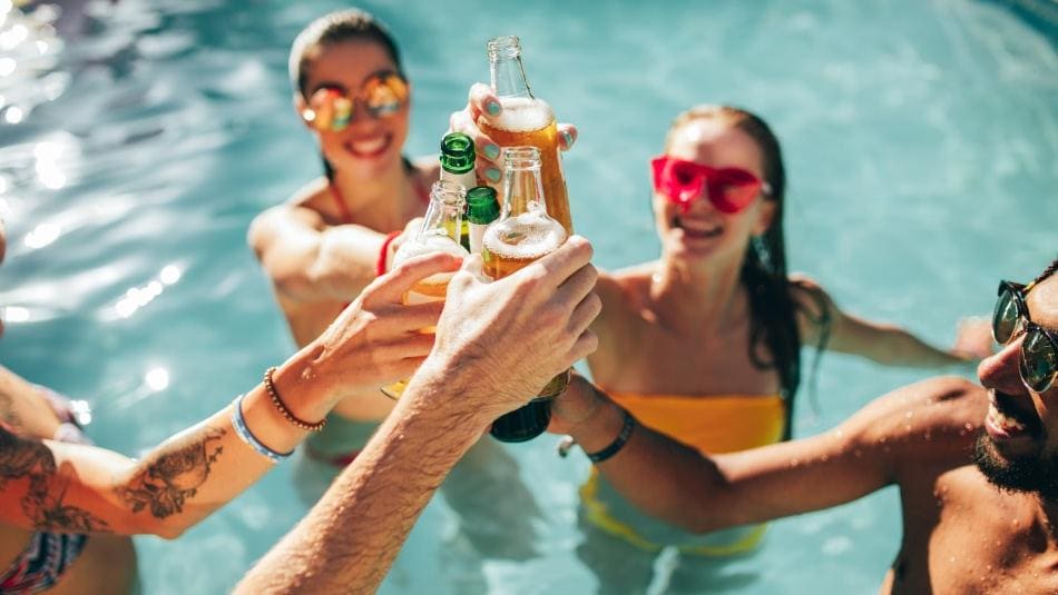 Coppia che brinda in piscina con una vassoio di cibi vicino All Inclusive