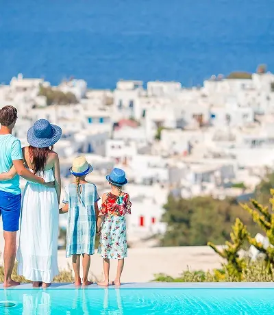 Genitori e bambini sullo sfondo della piscina all'aperto Città di Mykonos