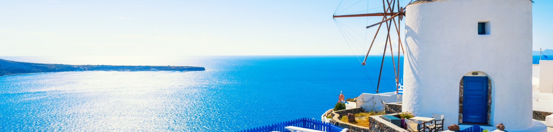 Architettura bianca nell'isola di Santorini, Grecia. Mulino a vento nella città di Oia in una giornata di sole.