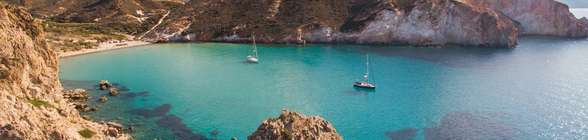 Barche a vela ancorate nella baia sull'isola di Milos