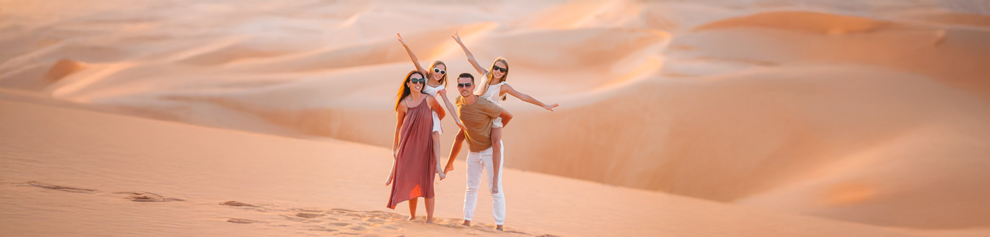 famiglia felice di genitori e due figlie nel deserto in Oman