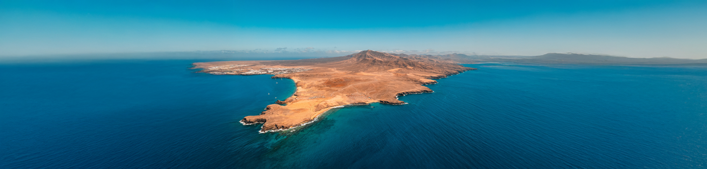 vista aerea su isola delle Canarie e distesa di mare azzurro con cielo limpido, Spagna