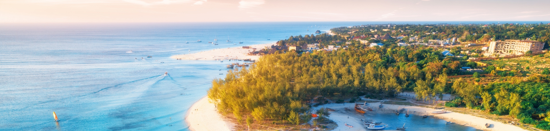 Vista aerea delle barche da pesca sulla costa tropicale del mare con spiaggia sabbiosa al tramonto. Viaggio estivo a Zanzibar, Africa. 