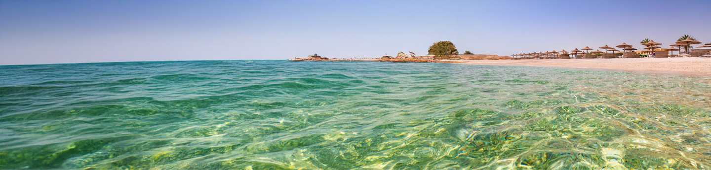 spiaggia di Marsa Alam con mare limpido e vista su ombrelloni, Egitto