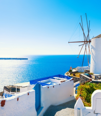 Architettura bianca nell'isola di Santorini, Grecia. Mulino a vento nella città di Oia in una giornata di sole.